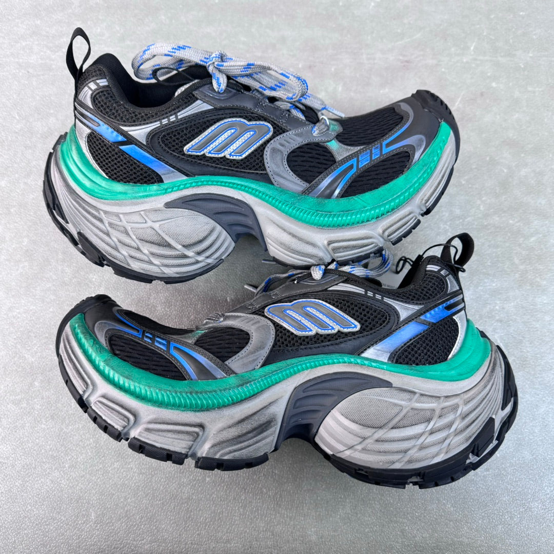 Unisex chunky sneakers, black and gray uppers with blue stripe details and green midsole trim.