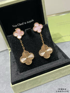 Gold-tone dangling earrings with pink four-leaf clover tops and flower drop charms