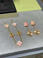 Gold-tone earrings with pink clover enamel and long chains ending in scalloped flower charms