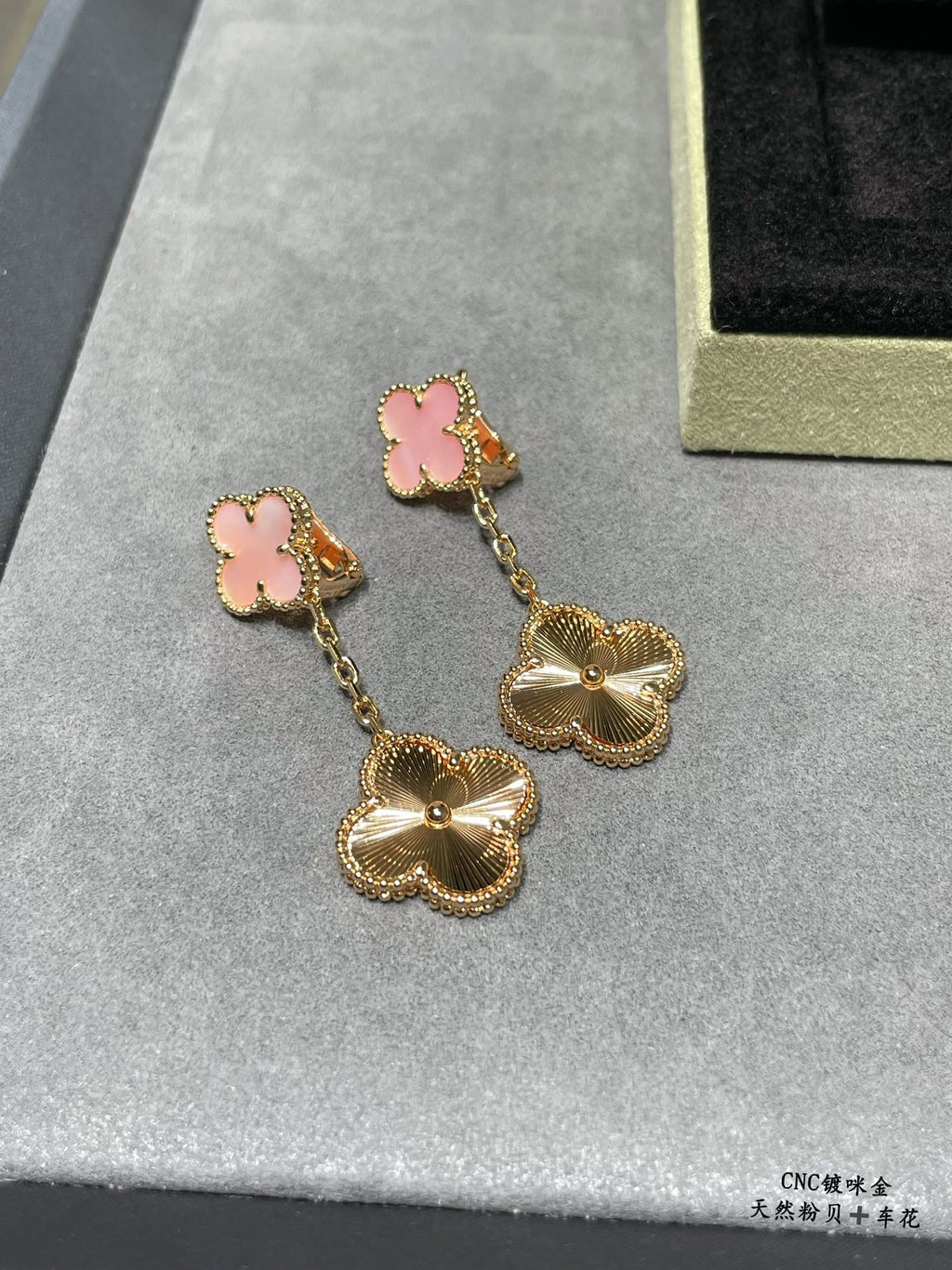 Gold-tone dangle earrings with pink clover studs and scalloped flower charms