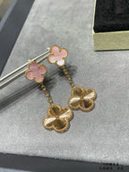 Gold-tone long dangle earrings with pink clover accents and scalloped flower drops