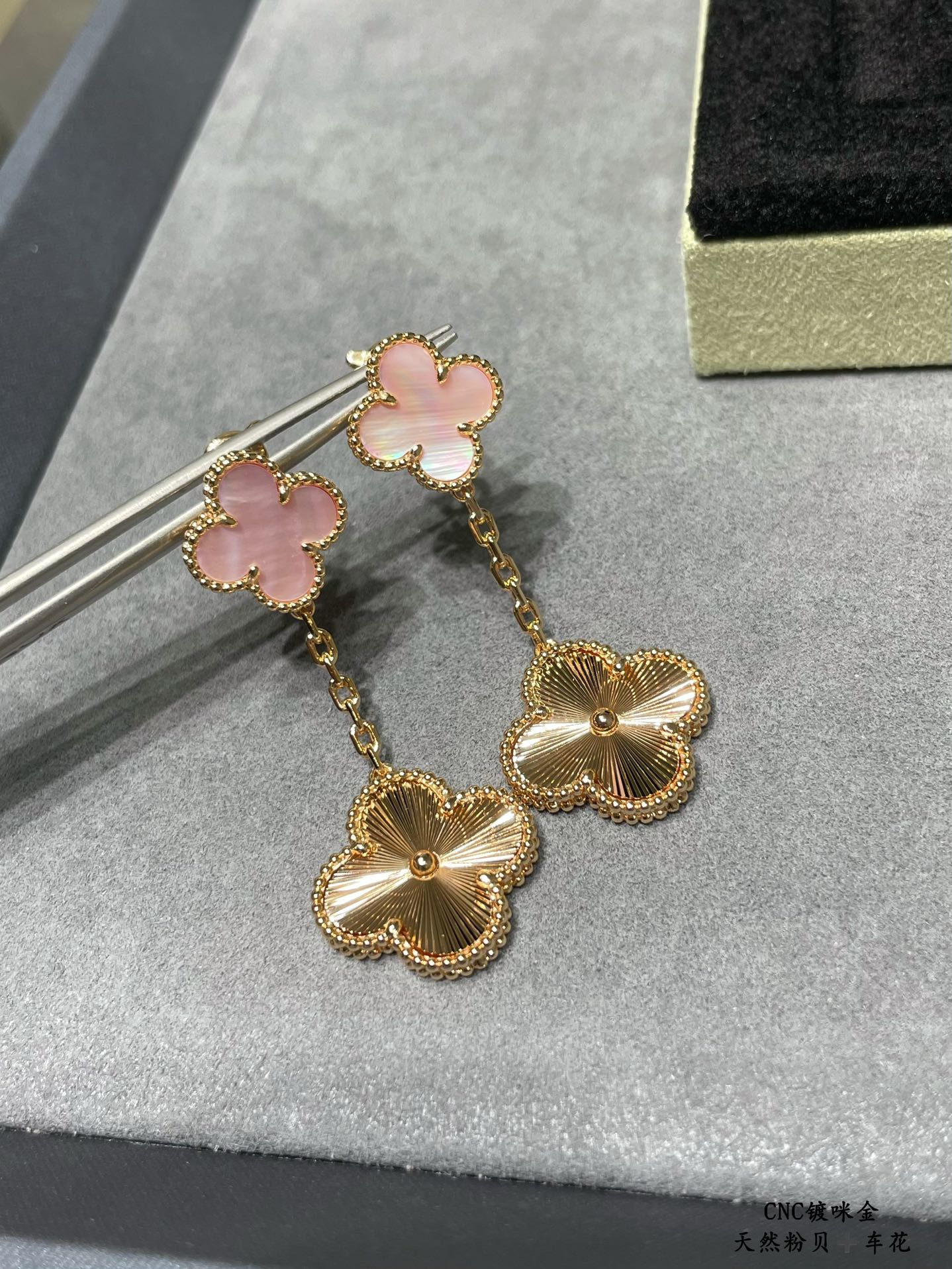Gold-tone long dangle earrings with pink clover accents and scalloped flower drops