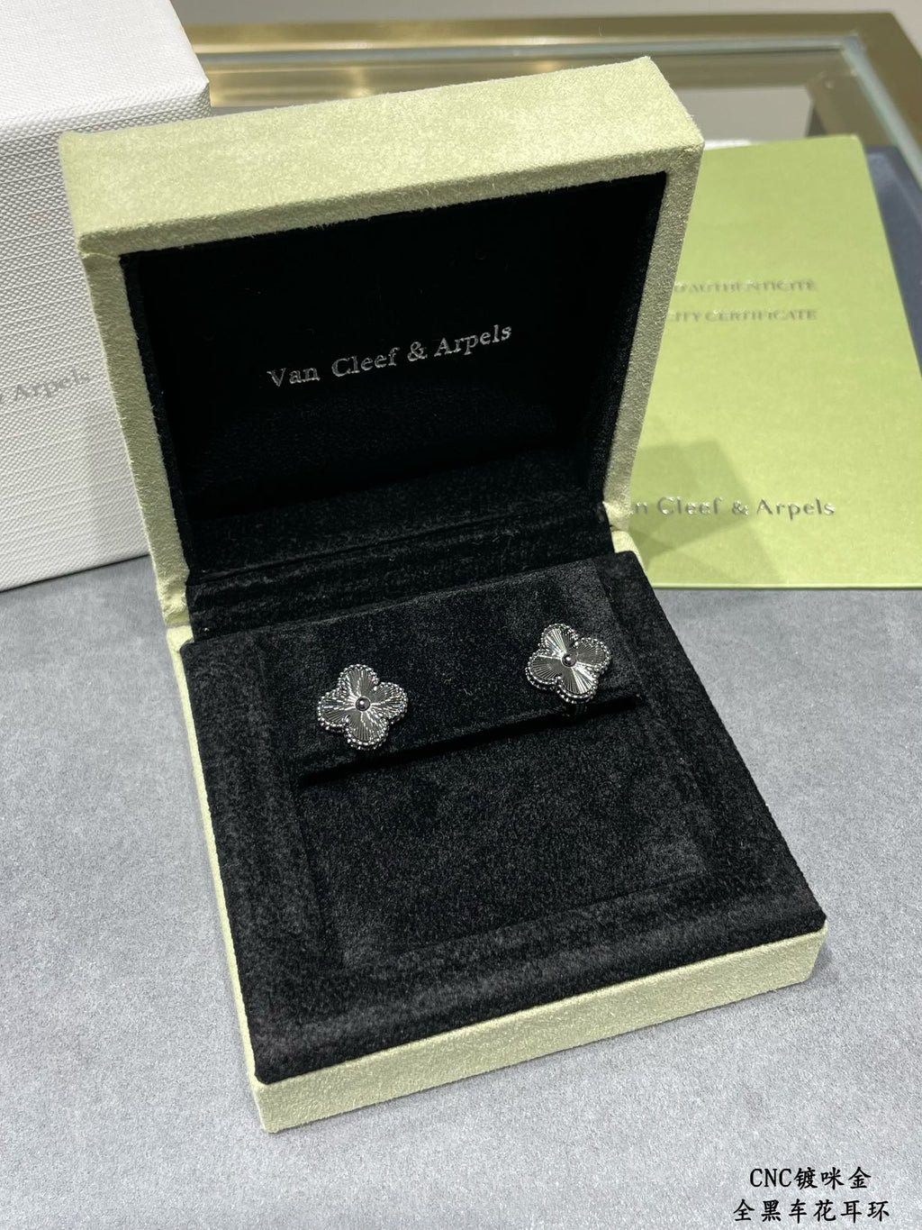 Quatrefoil stud earrings in black display box, silver-tone floral motif