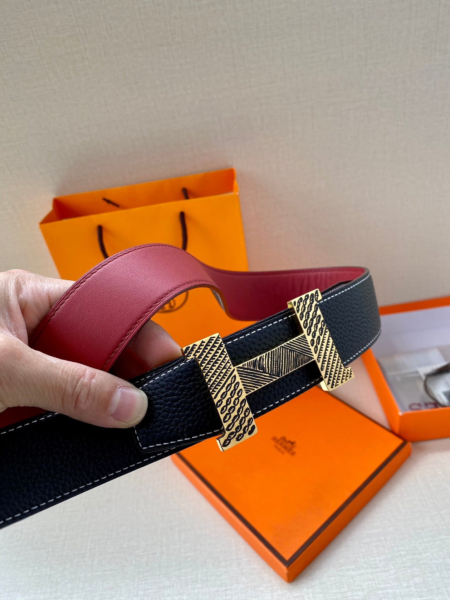 Hermes belt with dark blue strap and gold buckle, red interior side visible