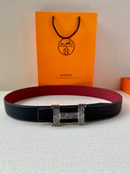 Hermes belt displayed flat: dark blue strap with red underside and patterned buckle