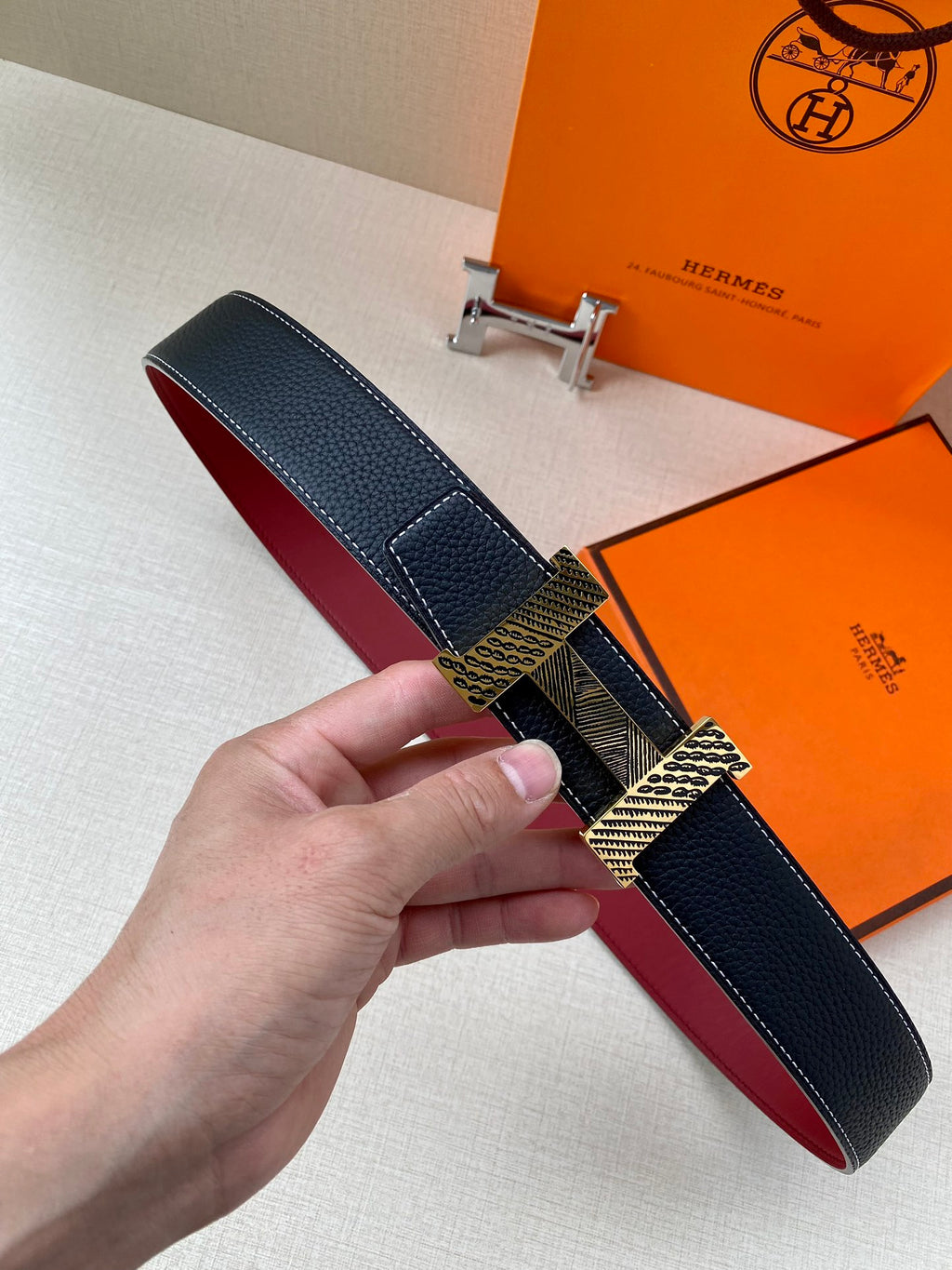 Hermes belt with dark blue textured leather strap and red underside, silver-tone buckle detail