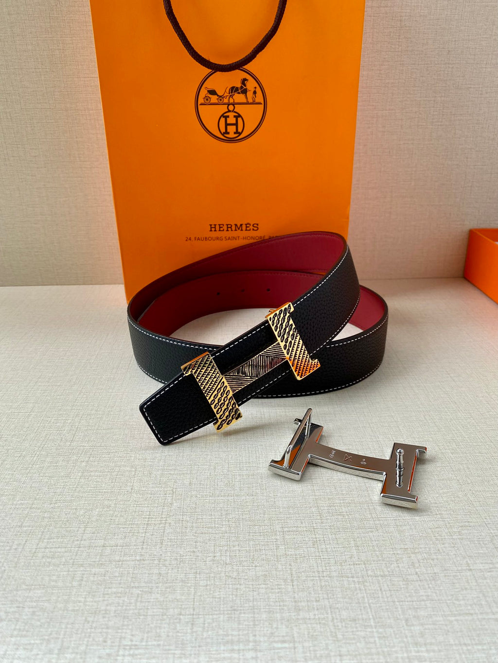 Hermes belt with dark blue leather and red lining, crosshatched buckle accent