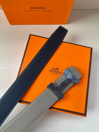 Grey leather belt with textured gold-tone clasp and dark lining strip, laid diagonally.