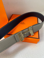 Grey leather belt with dark edge detail and textured gold-tone buckle clasp.
