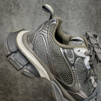 Balenciaga sneakers side angle with gray mesh upper, lace-up, white logo trim