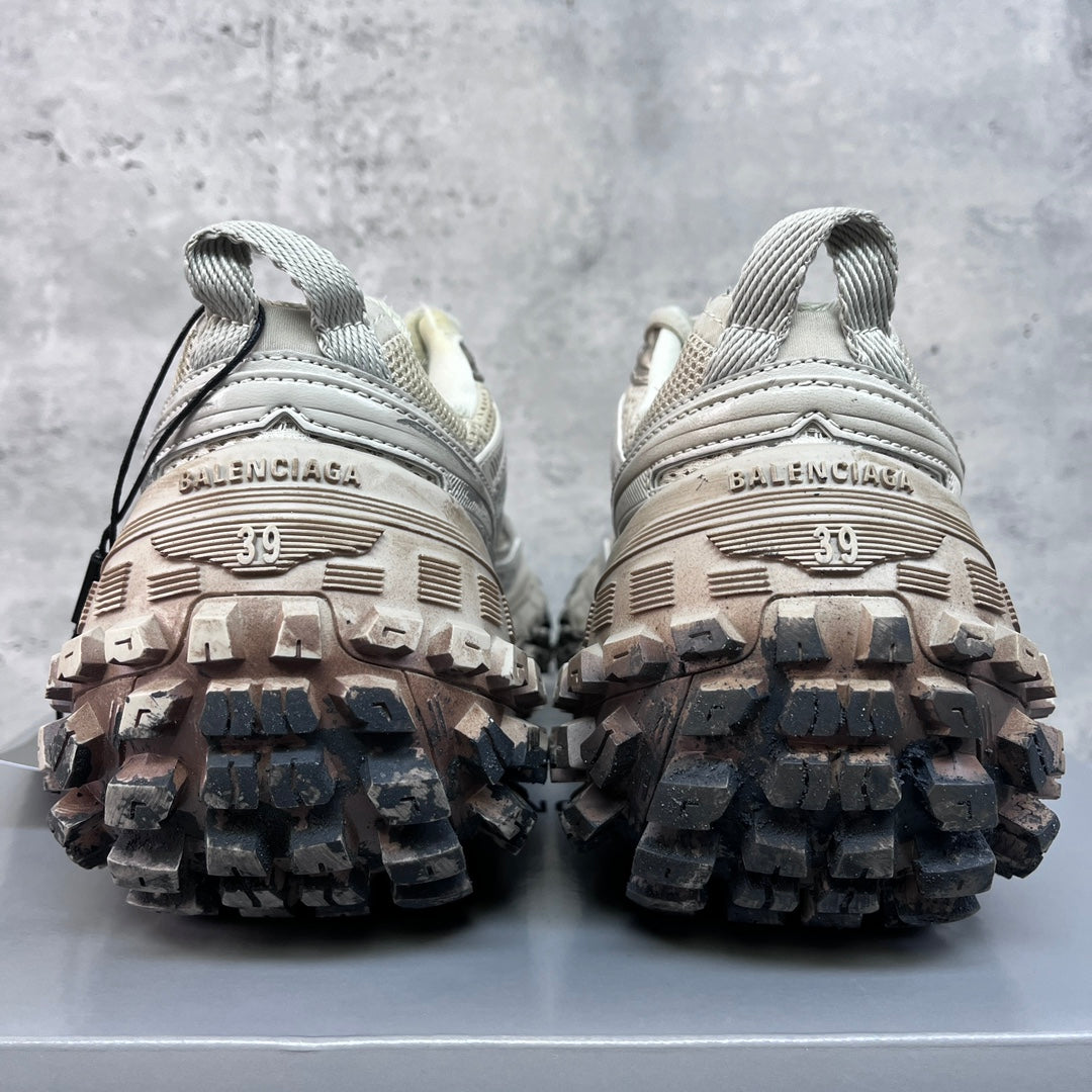 Unisex sneakers heel view, thick lug soles and light gray uppers with lace-up ties.