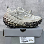 Unisex chunky lace-up sneakers with light gray uppers and rugged black/gray traction sole.