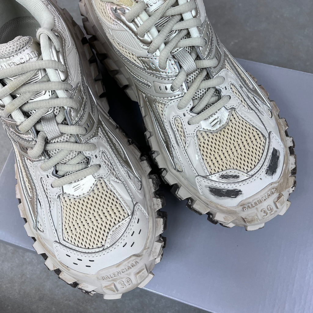 Unisex lace-up sneakers pair, light gray uppers with perforated panels and chunky tread soles.