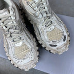 Unisex lace-up sneakers pair, light gray uppers with perforated panels and chunky tread soles.