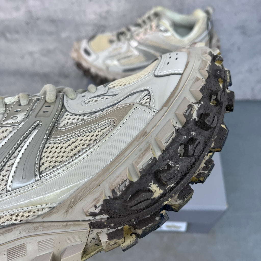 Unisex sneaker side view with textured panels, lace-up closure, and heavy traction tread.