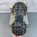 Unisex sneaker outsole view, thick multi-directional lugs with worn dark gray tread.