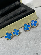 Blue clover stud earrings with gold-tone frames, arranged in a row
