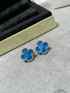 Two blue clover stud earrings with gold-tone frames on display