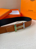 Brown leather belt with navy strap section and silver-tone buckle with striped inlays