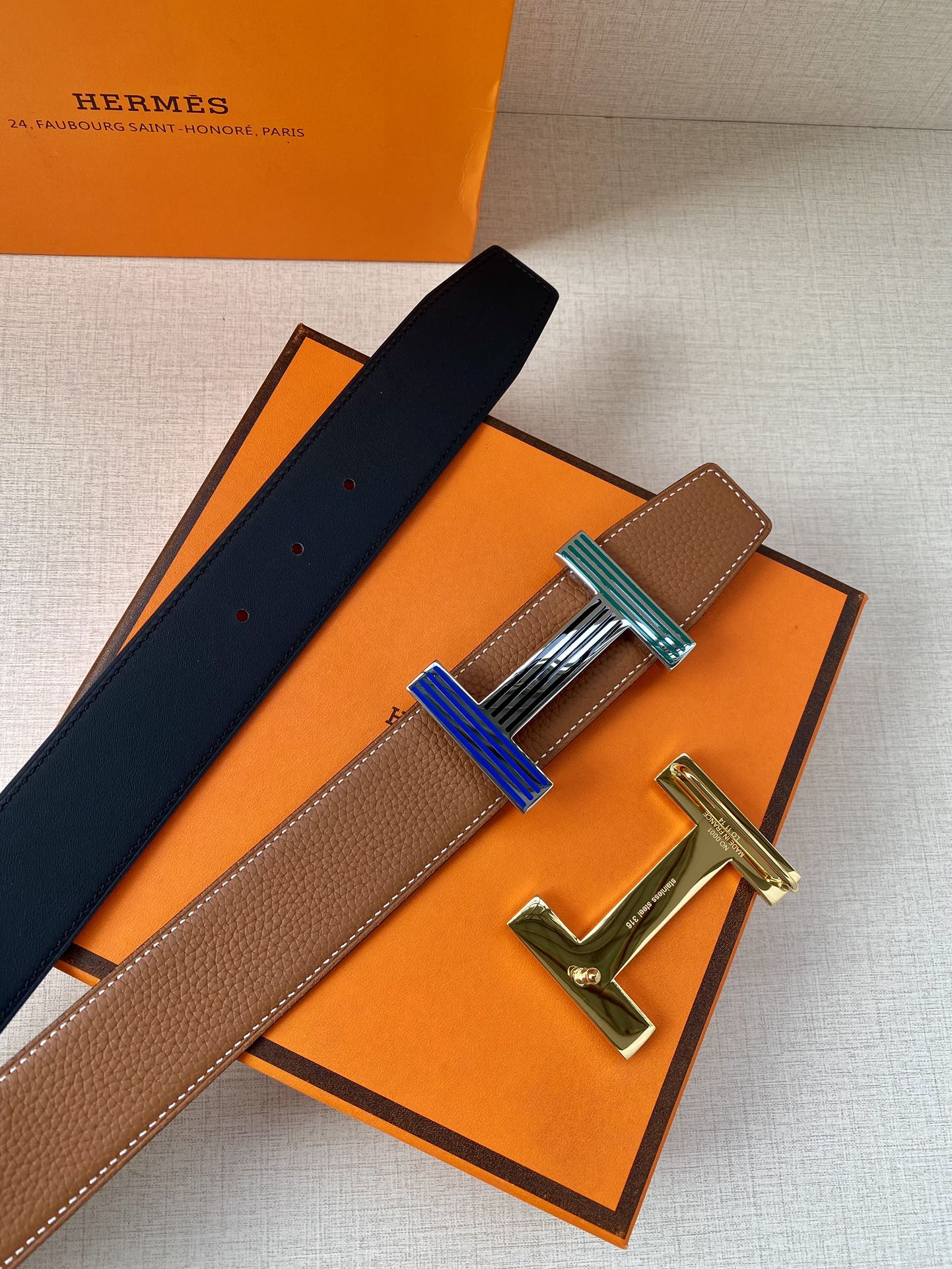 Brown leather belt with navy strap and striped buckle with silver-tone hardware