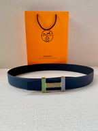 Blue leather belt with striped buckle and gold-toned clasp laid flat