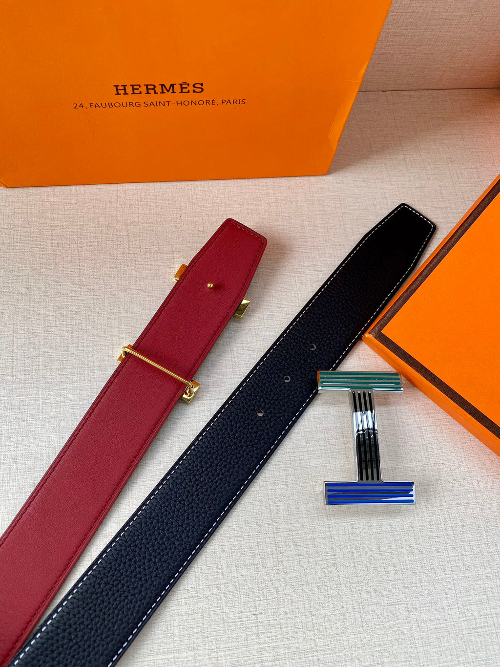 Hermes belt pair with burgundy and dark blue straps and striped buckle accents