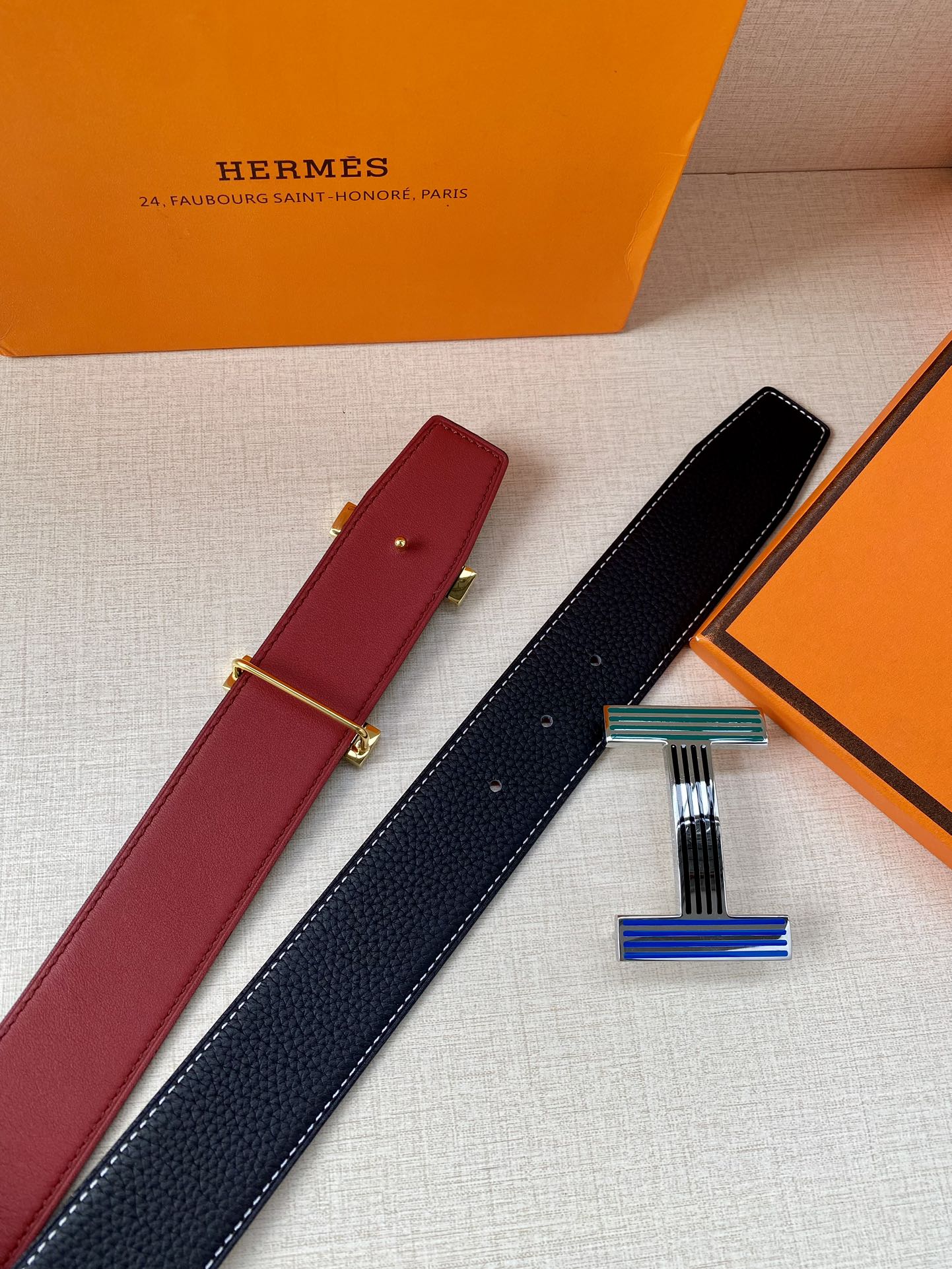 Hermes belt pair with burgundy and dark blue straps and striped buckle accents