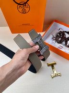 Hermes belt close-up of gray leather straps and woven keeper with gold H buckle