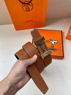 Hermes leather belt with brown strap, patterned buckle plate, and metal bar