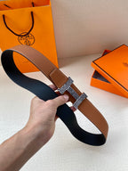 Hermes leather belt with brown strap and black underside, silver-tone buckle