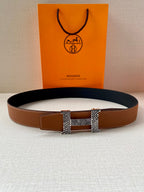 Hermes leather belt with brown strap and silver-tone buckle, laid flat