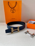 Navy blue leather belt with gold-tone buckle plates and silver prong hardware