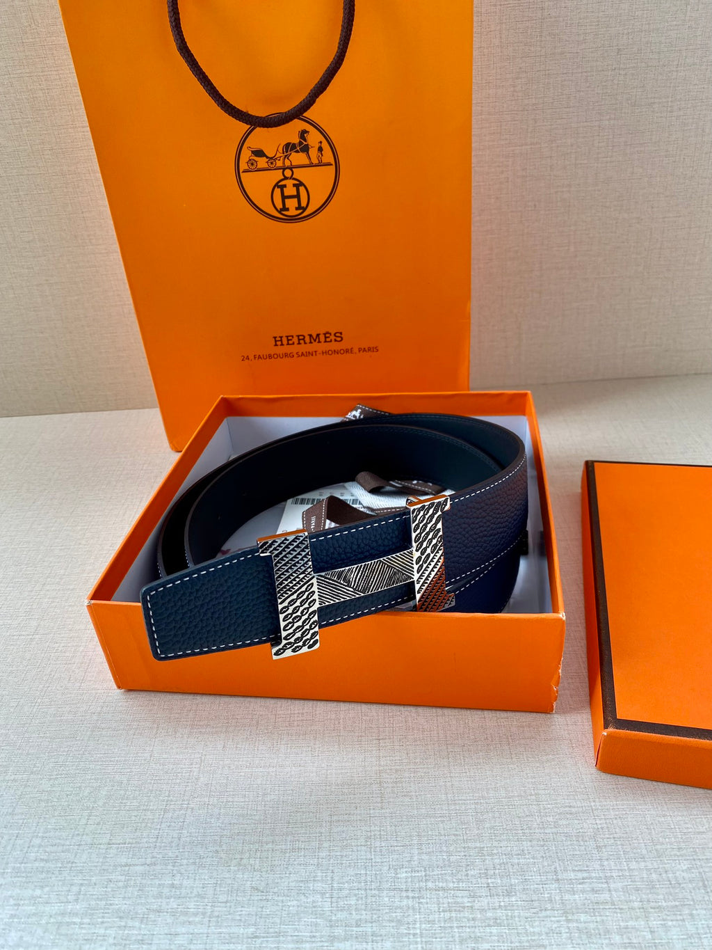 Navy blue leather belt with gold-tone buckle plates and textured center strap