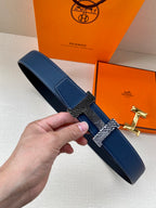 Blue leather belt with silver buckle and gold-toned keeper, textured strap detail