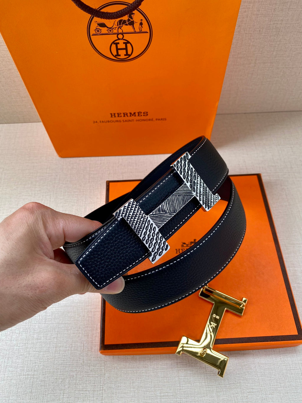 Blue leather belt with silver prong buckle and gold-tone strap buckle details