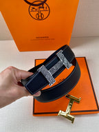 Blue leather belt with silver prong buckle and gold-tone strap buckle details
