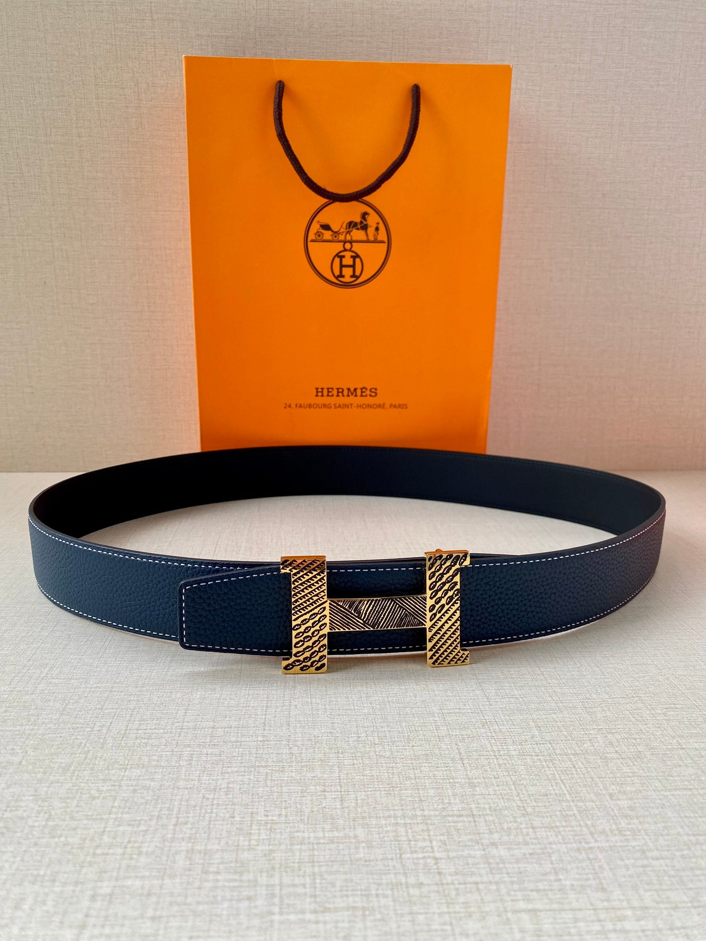 Navy blue leather belt with gold-tone buckle plates and textured center panel