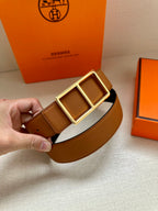 Hermes belt close-up: tan textured strap with gold-tone double square buckle