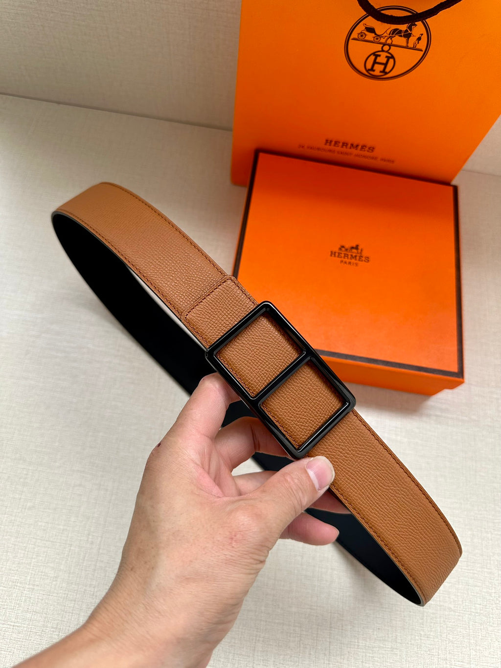 Hermes belt in tan leather with black underside and square buckle detail