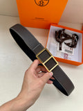Leather belt with textured dark strap and gold-tone square buckle, held in hand