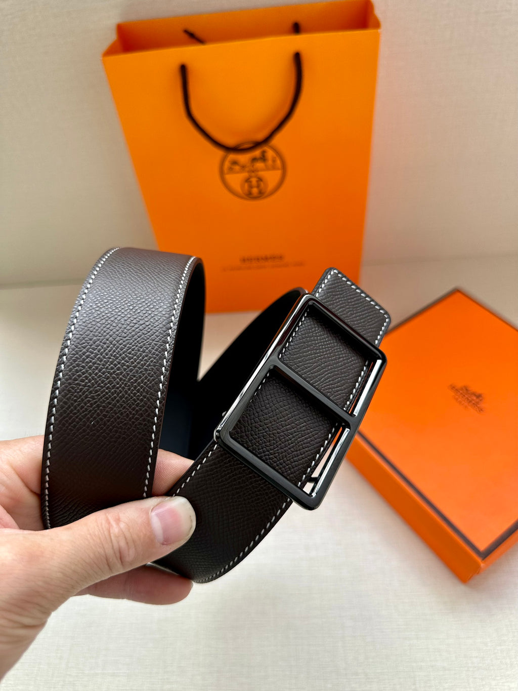 Leather belt with textured dark strap and silver-tone pin buckle, side angle