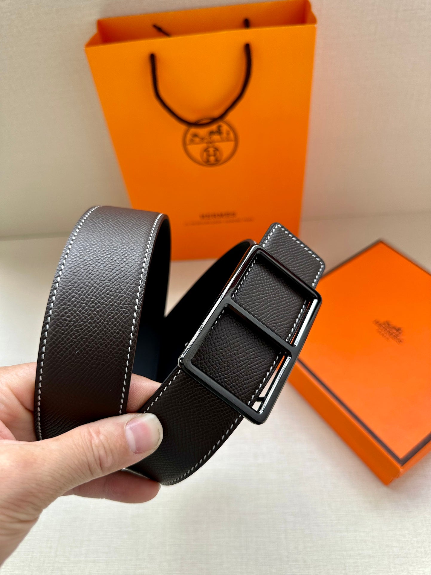 Leather belt with textured dark strap and silver-tone pin buckle, side angle