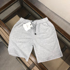 Light gray drawstring shorts with elastic waist, front pocket, and black cord