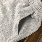 Light gray elastic waistband with drawstring and stitched pocket opening