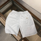 Light gray drawstring shorts with elastic waist and small logo patch