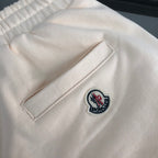 Stone Island shorts front pocket with Moncler logo patch on light cream fabric