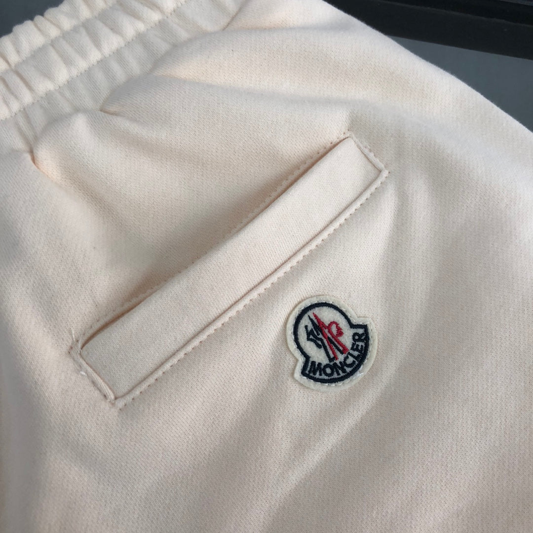 Stone Island shorts front pocket with Moncler logo patch on light cream fabric