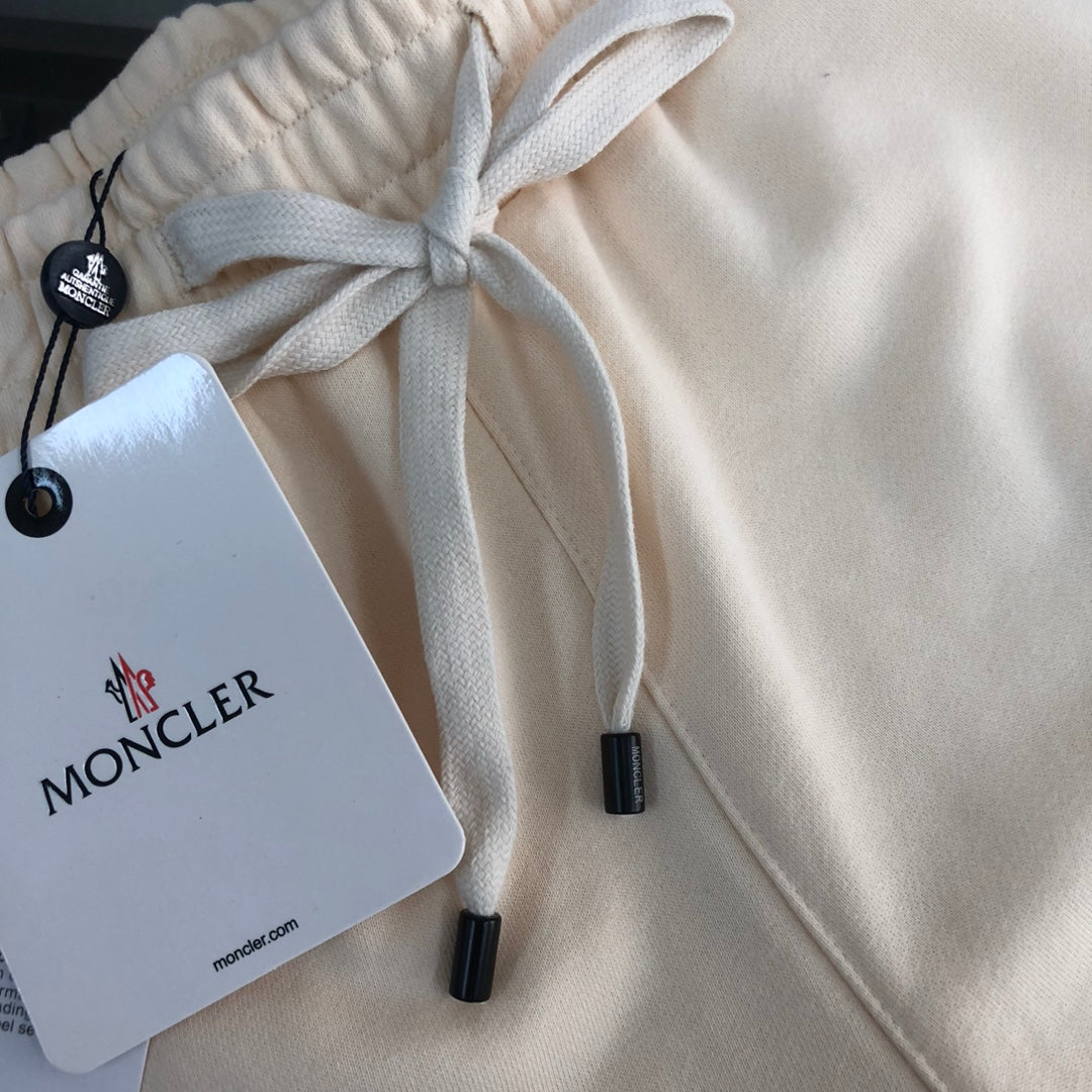 Stone Island shorts close-up of drawstring and Moncler logo tag on cream fabric