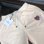 Stone Island cream shorts with elastic waistband, drawstring, and red logo patch