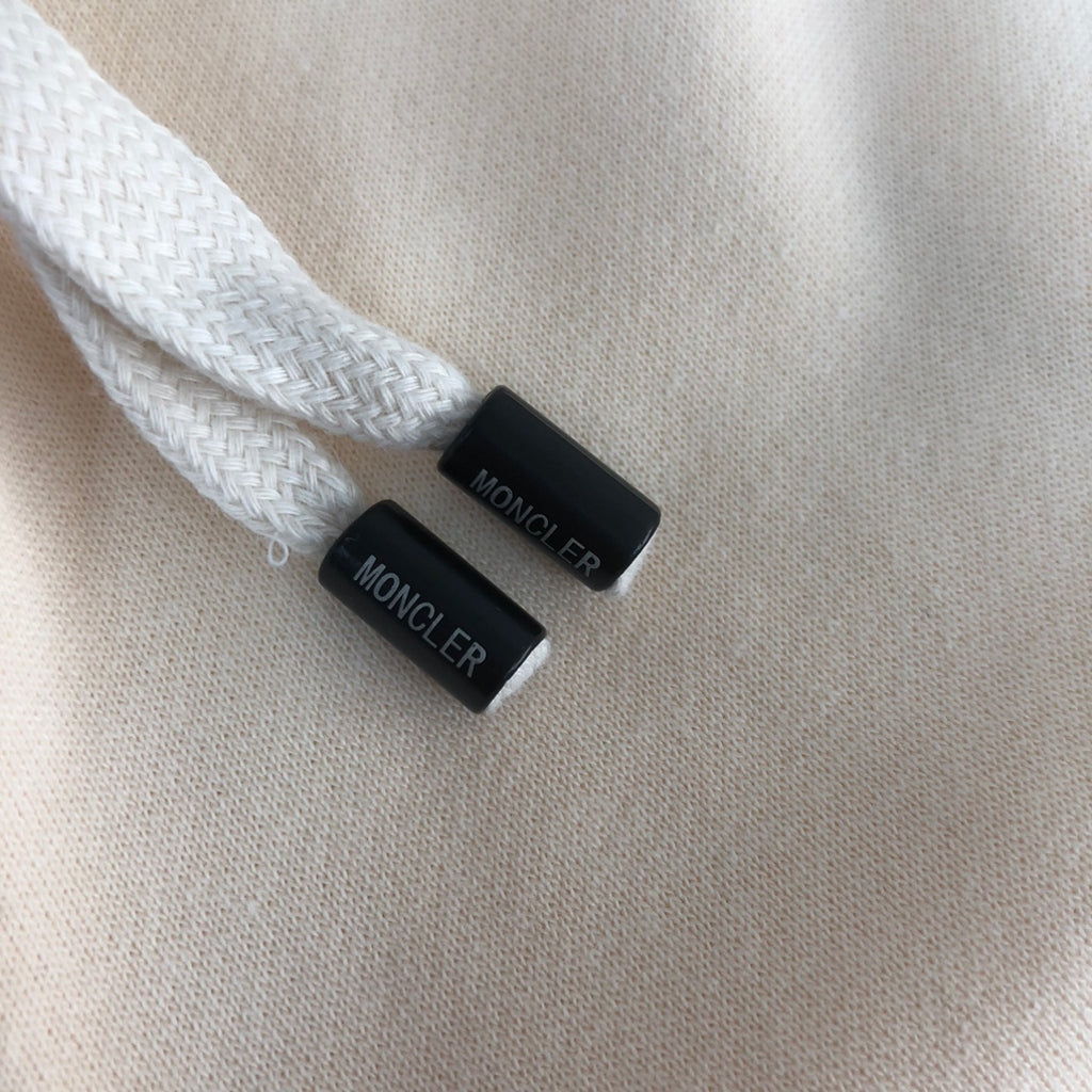Stone Island shorts drawstring cord ends with Moncler print on cream fabric